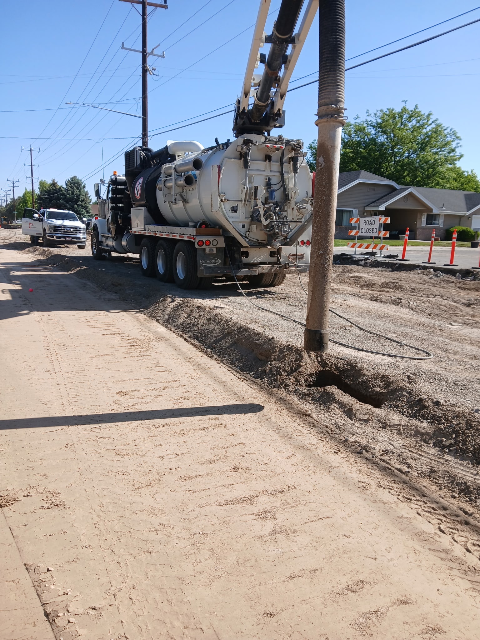 Hydrovac vacuum truck performing sewer line cleaning