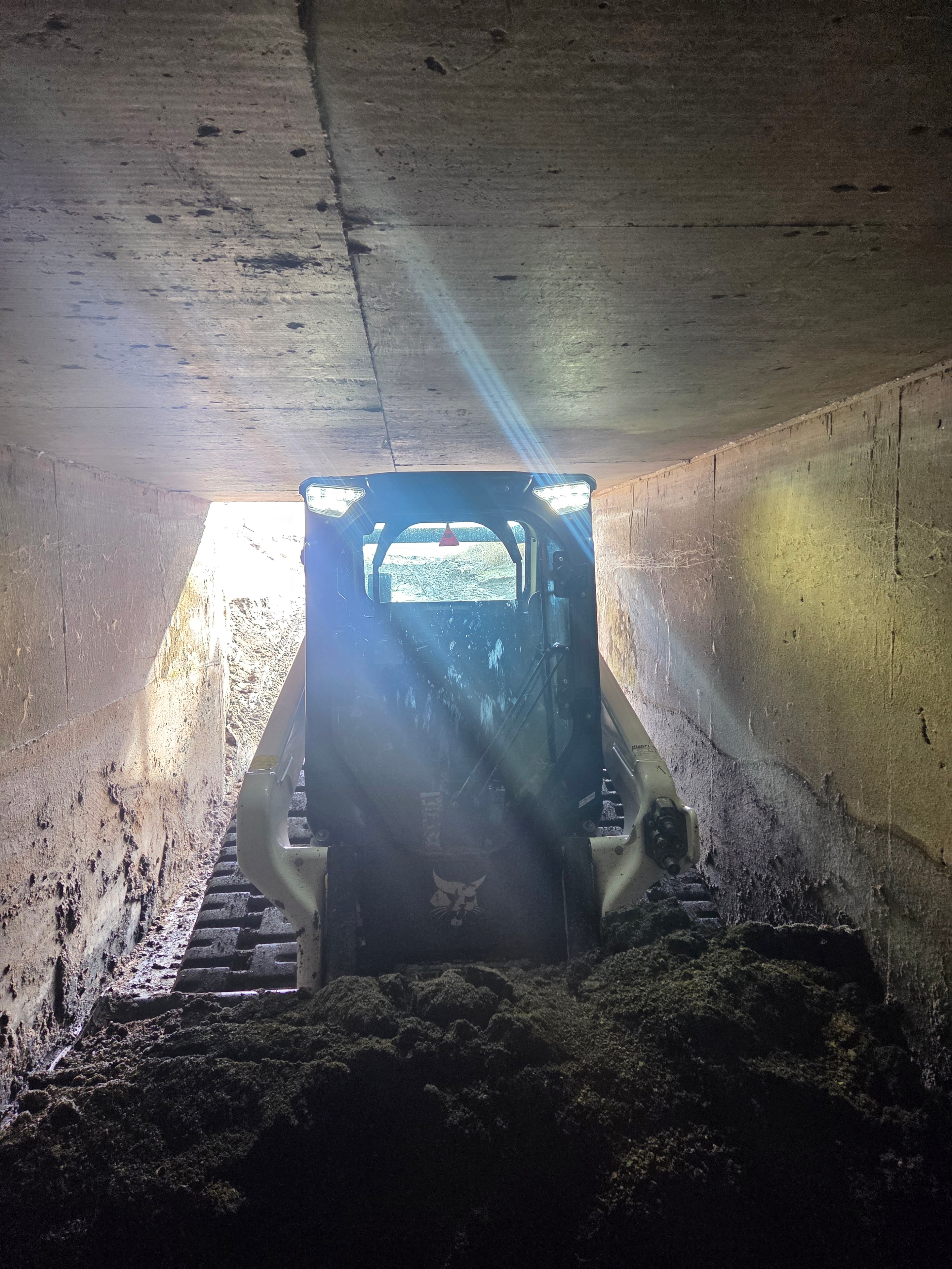 Skid steer inside ITD siphon tunnel during cleaning